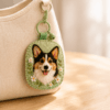 Custom dog portrait felt charm attached to a canvas bag, featuring a handmade wool felt pet portrait with floral embroidery in a warm home setting