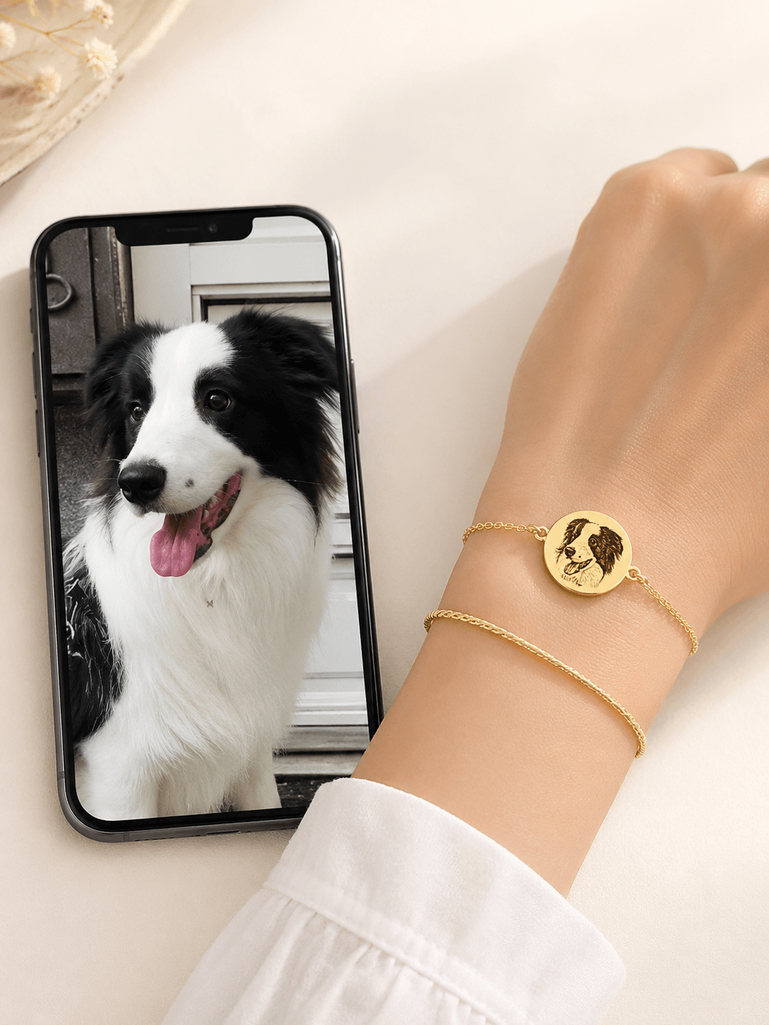Delicate gold pet portrait bracelet worn on the wrist with soft knit sleeve styling