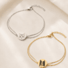 Gold and silver personalized pet portrait bracelets displayed on soft ivory fabric