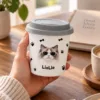 Personalized pet ceramic cup being held at a warm neutral desk.